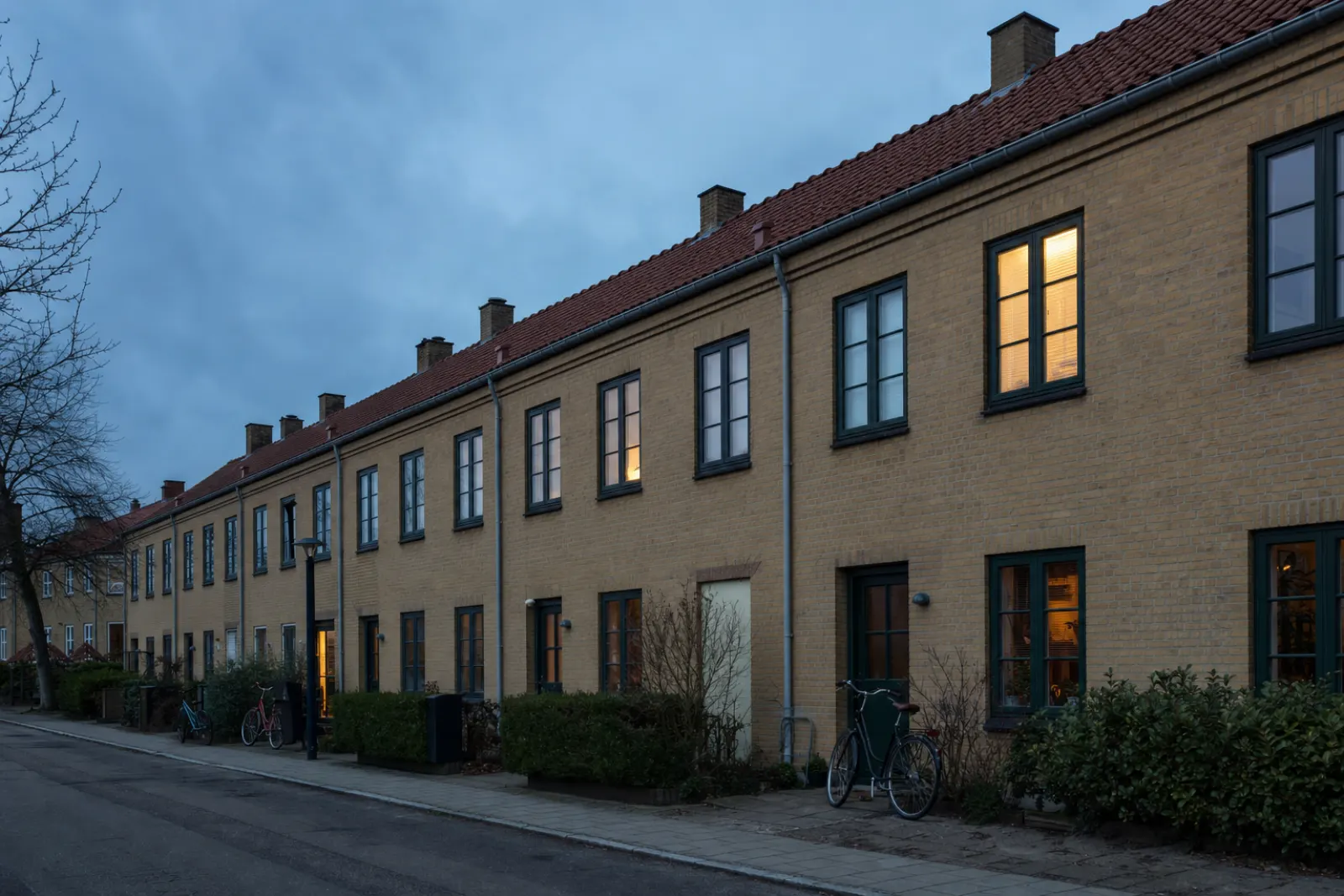 Gade med gule rækkehuse i aftenlys